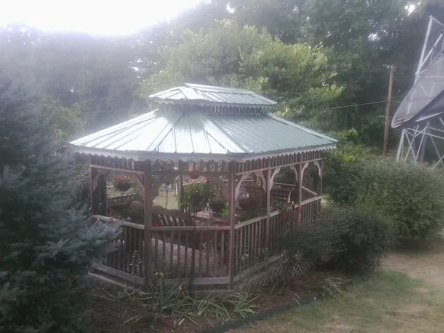 Green metal roof on a backyard gazebo surrounded by garden beds in York